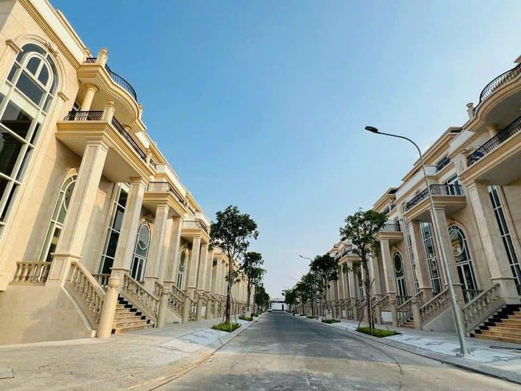 Con đường trong khu biệt thự Sunlake Villas Vạn Phúc City, hai bên là dãy biệt thự tân cổ điển màu vàng kem với cửa kính vòm và bậc thềm