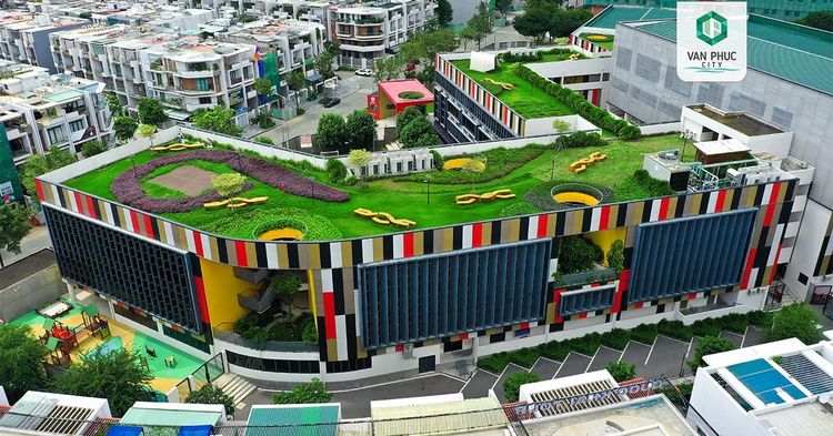 Sân thượng phủ cỏ có đường chạy và họa tiết màu trên nóc khối nhà sọc màu của trường EMASI