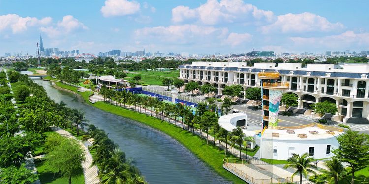 Kênh Sông Trăng uốn lượn giữa hai bờ cây xanh, bên cạnh dãy nhà phố và tháp leo núi nhiều màu