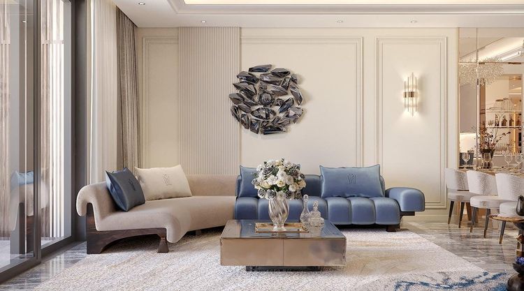 Phối cảnh phòng khách tân cổ điển với sofa cong màu be, sofa nhung xanh dương chần ô và tường phào chỉ trắng kem căn hộ mẫu Neoclassic