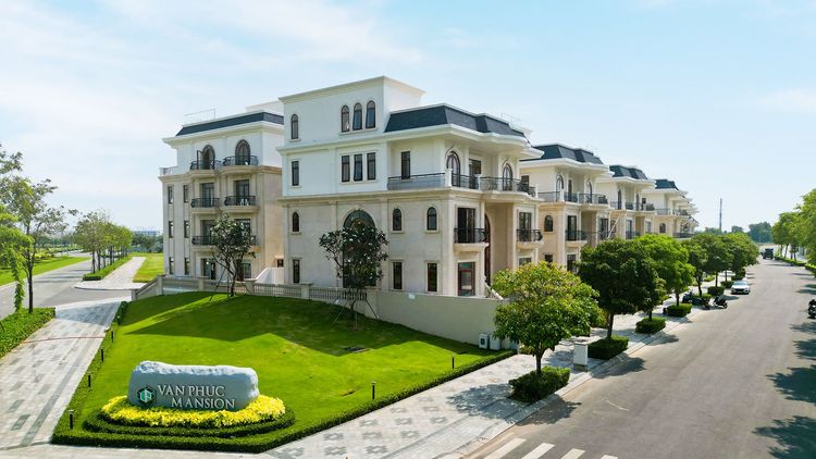Dãy biệt thự Van Phuc Mansion màu trắng với bảng tên phân khu và thảm cỏ phía trước