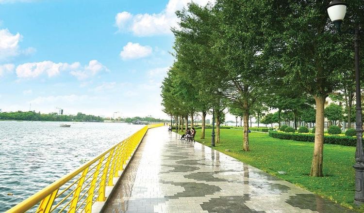 Lối đi bộ ven sông Sài Gòn có lan can vàng và hàng cây xanh tại công viên The Long Park, Vạn Phúc City