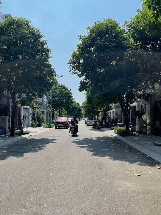 Đường nội khu rợp cây xanh trước dãy nhà phố tại Vạn Phúc City, ô tô và xe máy đậu dọc hai bên