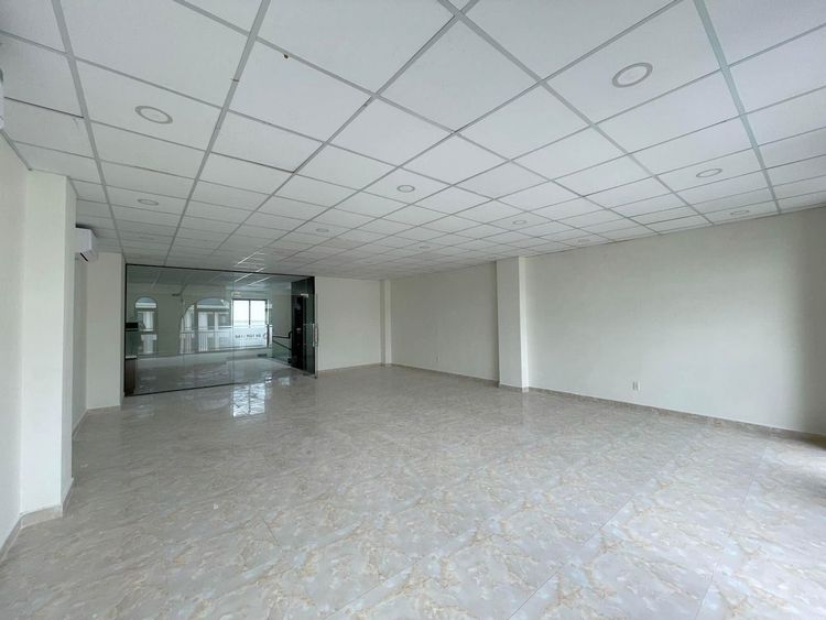 Sàn văn phòng trống đã hoàn thiện với trần thạch cao, đèn âm trần, máy lạnh và vách kính trong căn nhà phố 7x20 m